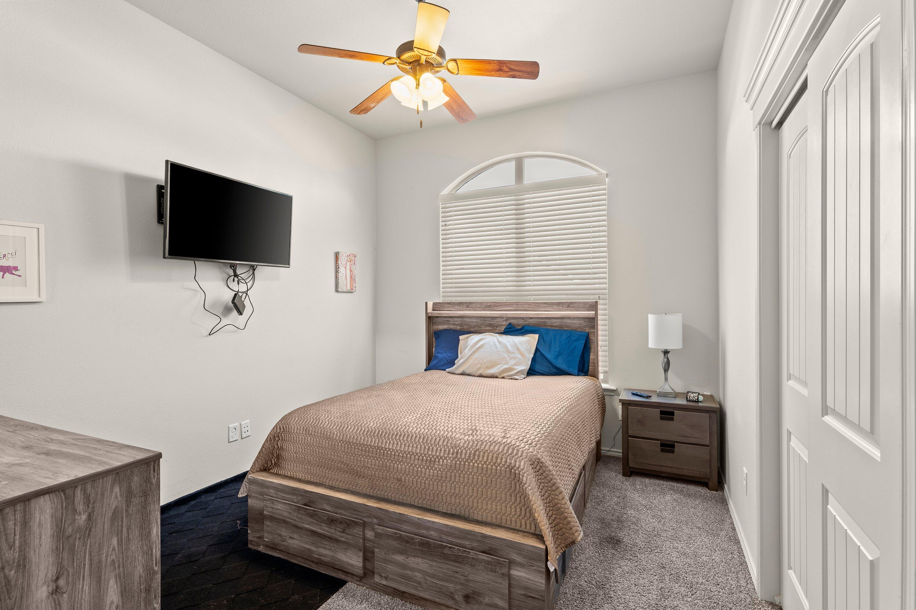 6305 93rd Street Lubbock, TX 79424 - Photo 24 of 31 a bedroom with a bed and a flat screen tv