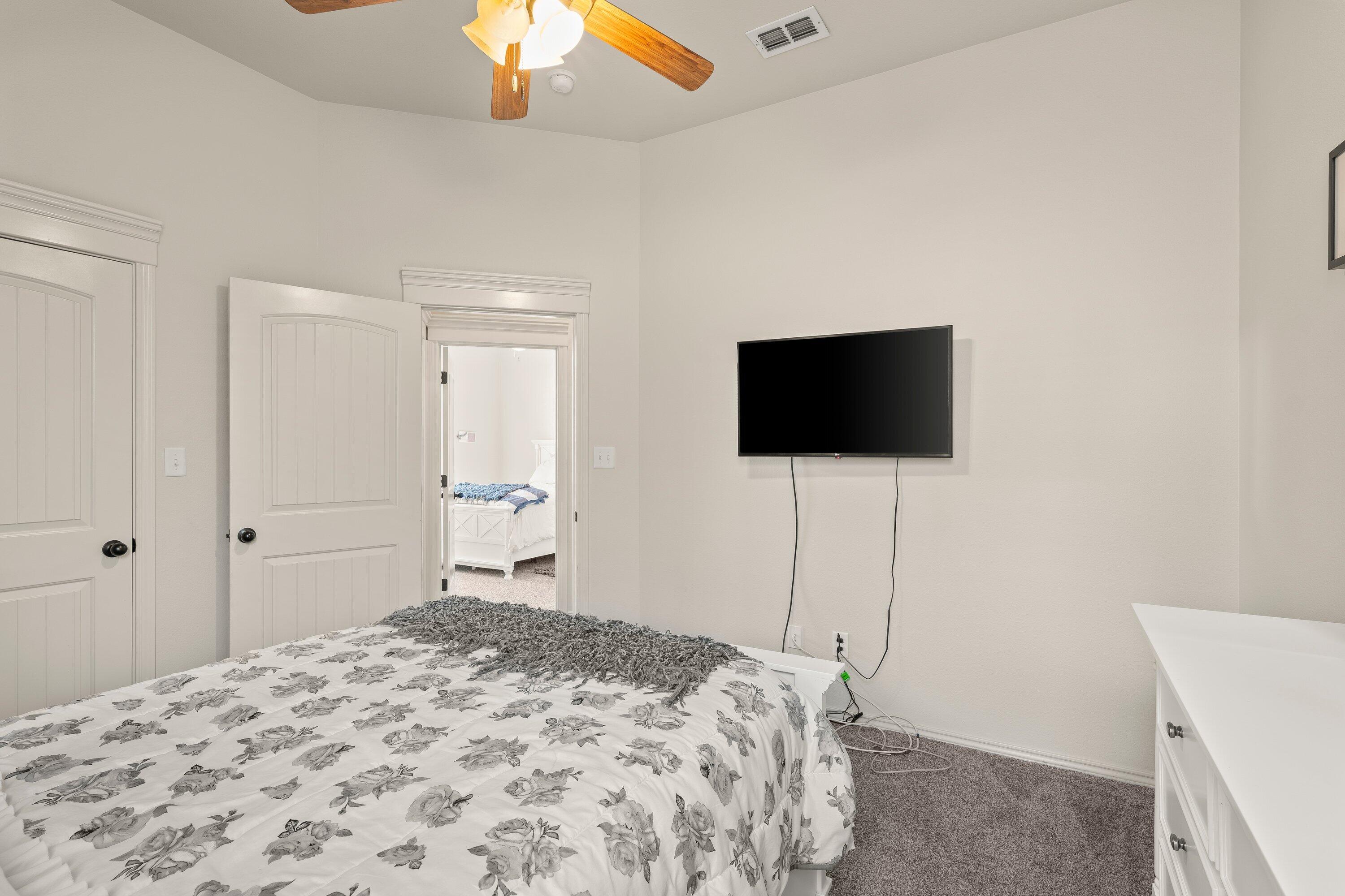 6305 93rd Street Lubbock, TX 79424 - Photo 27 of 31 a bedroom with a bed and a flat screen tv