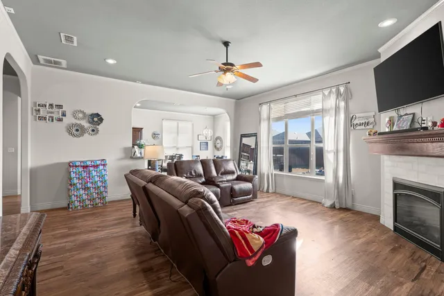 a living room with furniture a flat screen tv and a fireplace