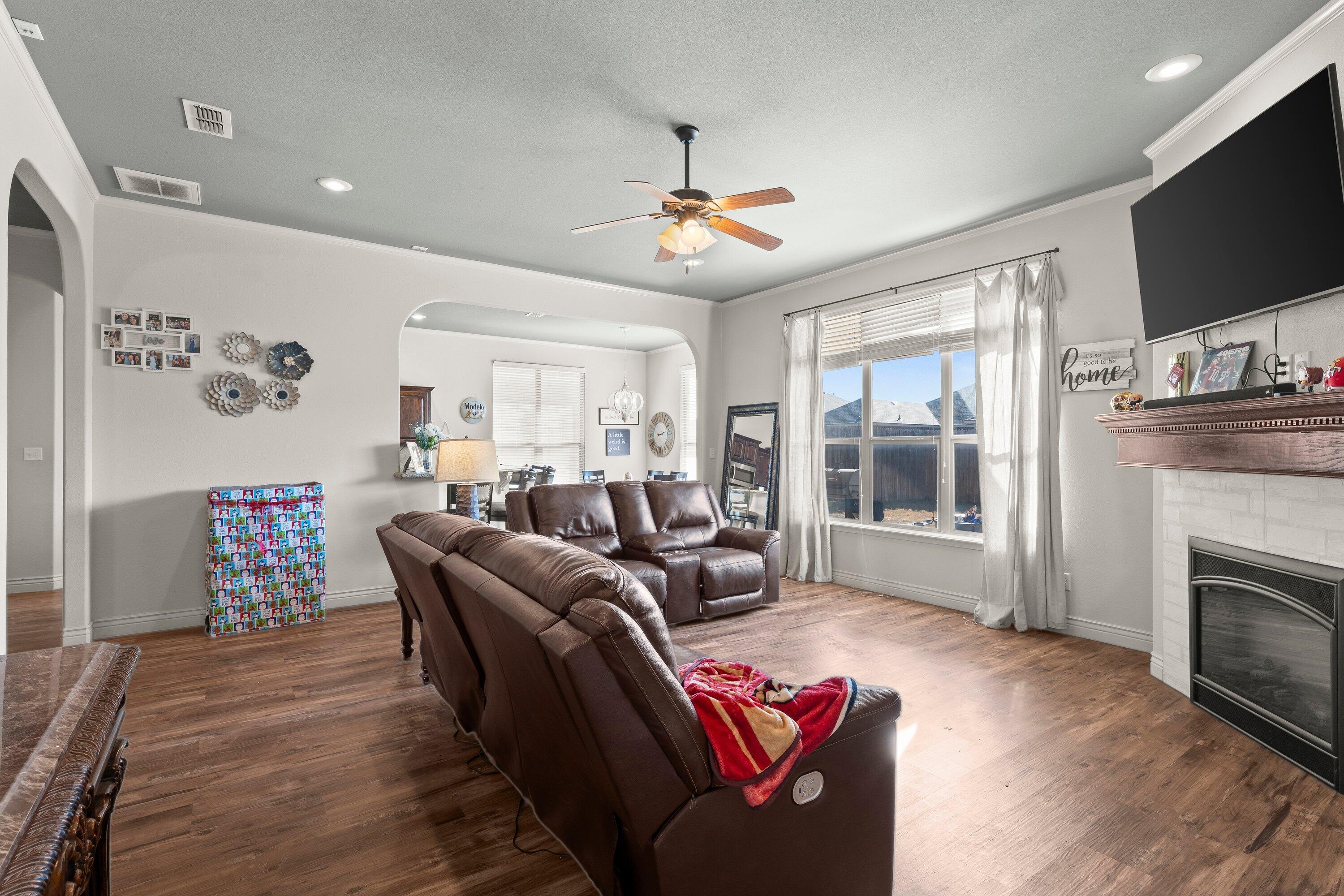 6305 93rd Street Lubbock, TX 79424 - Photo 7 of 31 a living room with furniture a flat screen tv and a fireplace
