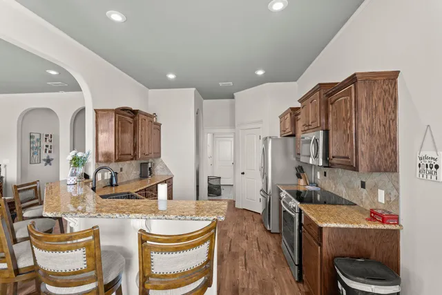 a living room with kitchen furniture and a wooden floor