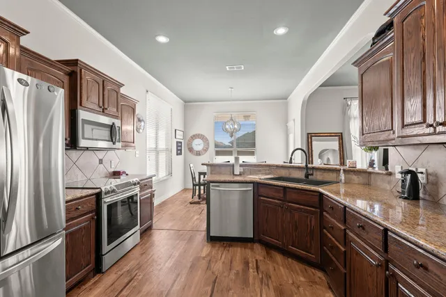 a kitchen with stainless steel appliances granite countertop lots of counter top space a sink and cabinets