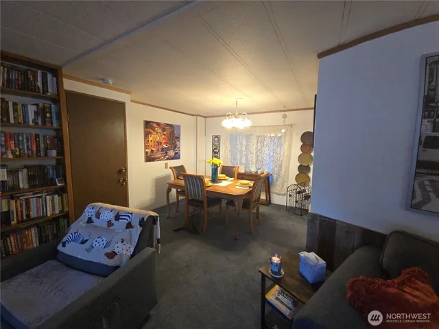 a living room with furniture a bookshelf and a window