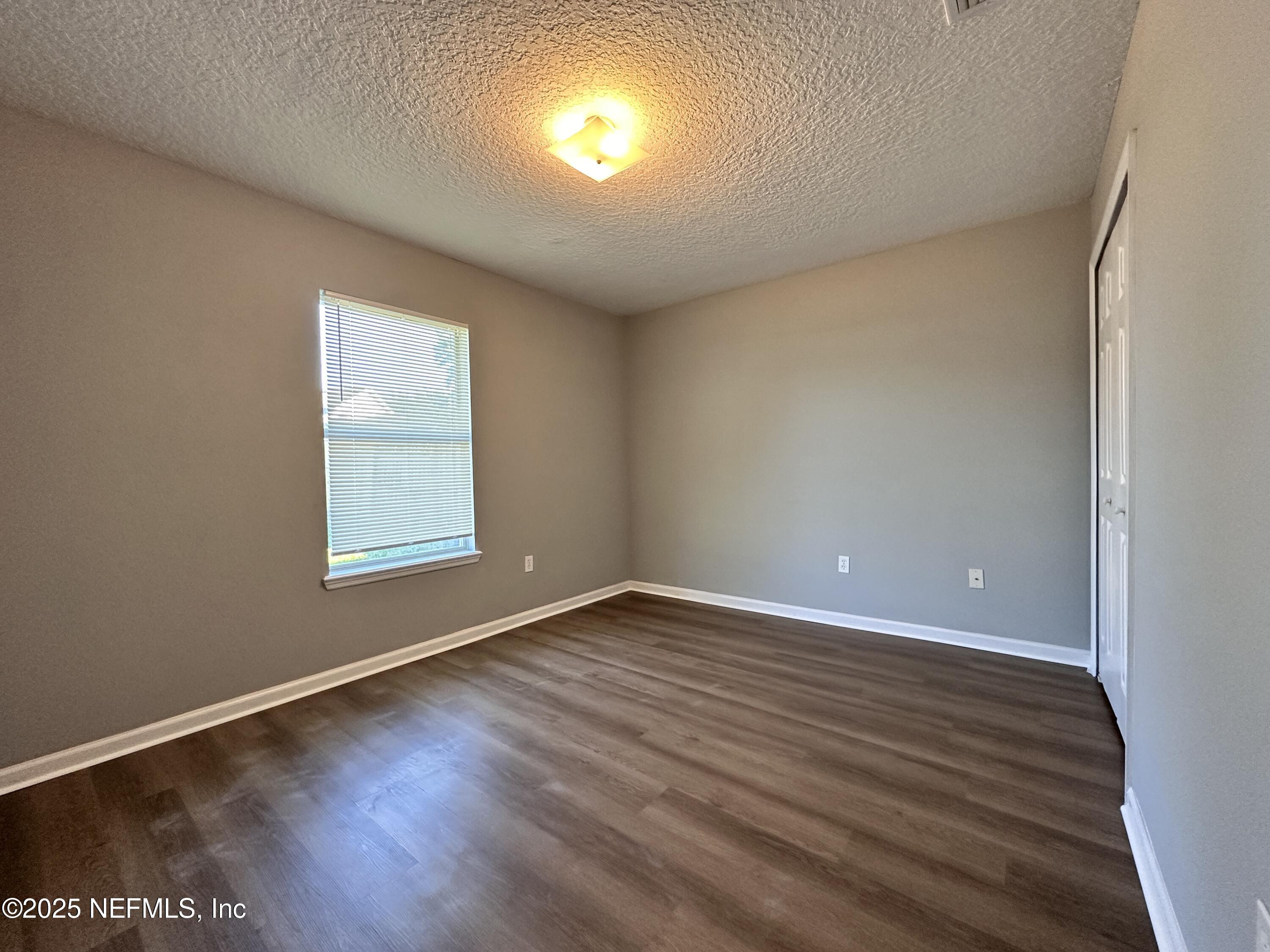 2786 Cross Creek Drive Green Cove Springs, FL 32043 - Photo 12 of 16 an empty room with wooden floor and windows