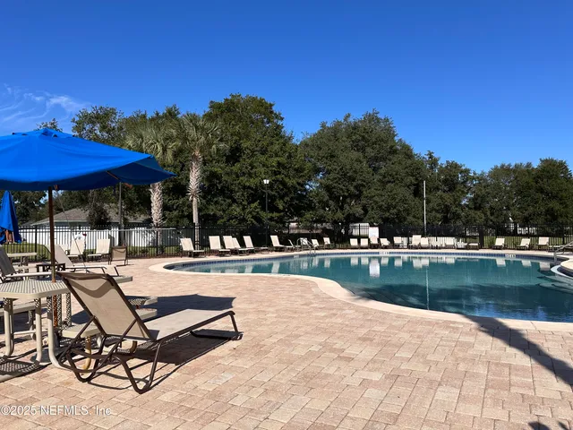 a view of a swimming pool with chairs in patio