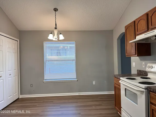 a kitchen with kitchen island granite countertop a sink cabinets stainless steel appliances and a window