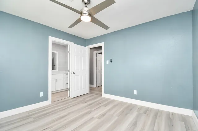 an empty room with a ceiling fan and hardwood floor