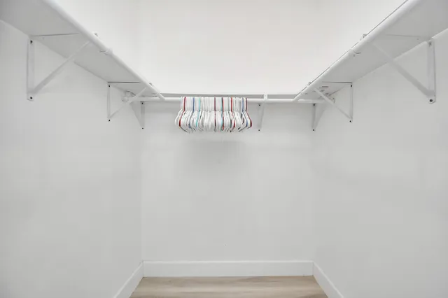 a view of walk in closet with racks on the wall