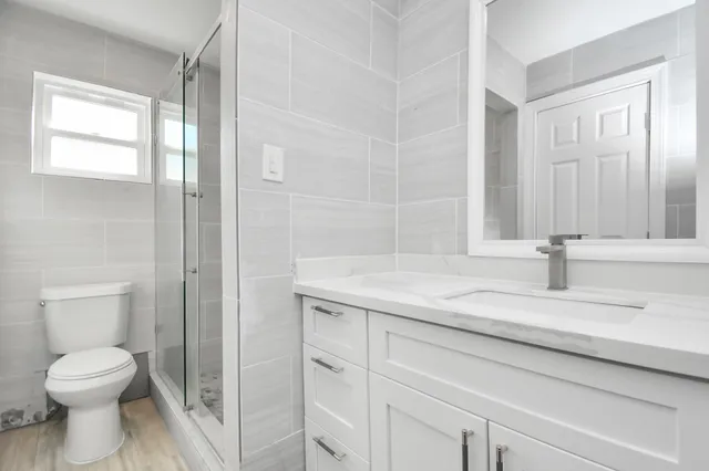 a bathroom with a granite countertop sink toilet and shower