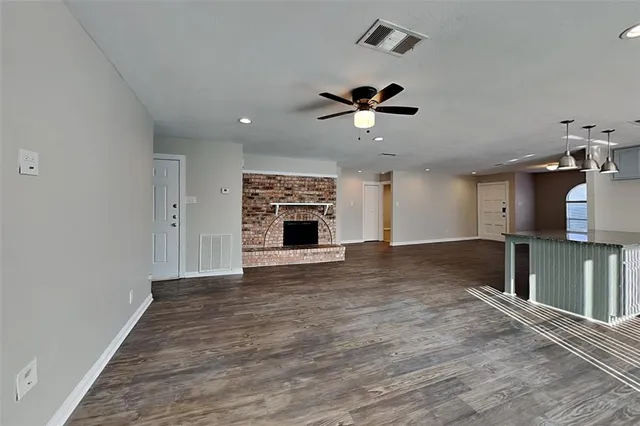 an empty room with windows and fireplace