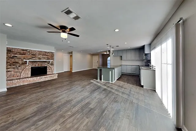 a view of kitchen with stainless steel appliances kitchen island wooden floor and chandelier