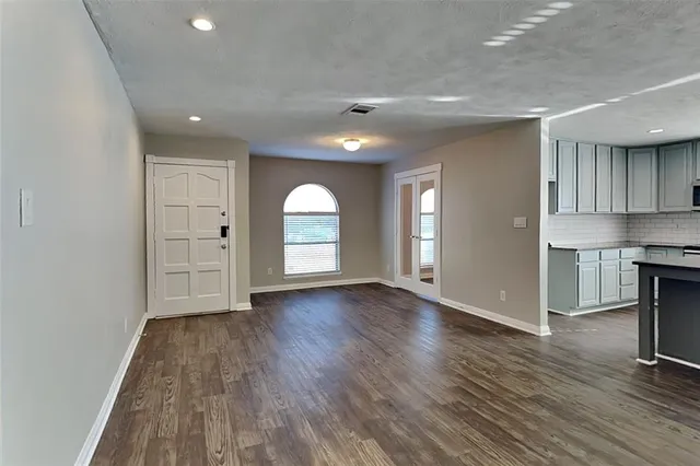 a kitchen with kitchen island granite countertop a sink cabinets and stainless steel appliances