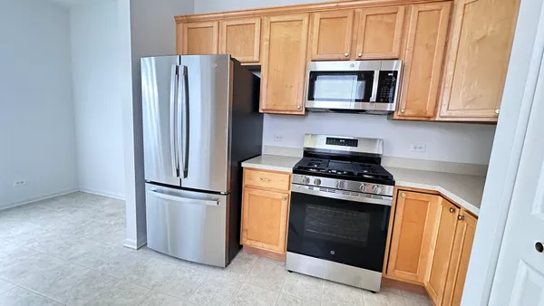 a kitchen with stainless steel appliances granite countertop a refrigerator stove and microwave