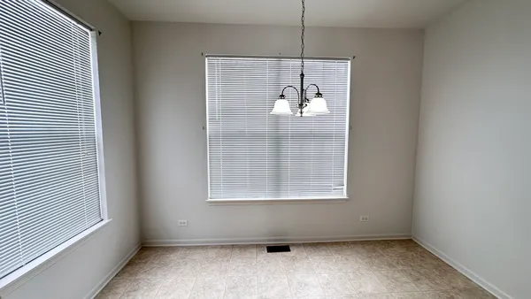 an empty room with a window and a ceiling fan