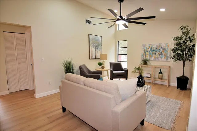 a living room with furniture and a large window with wooden floor