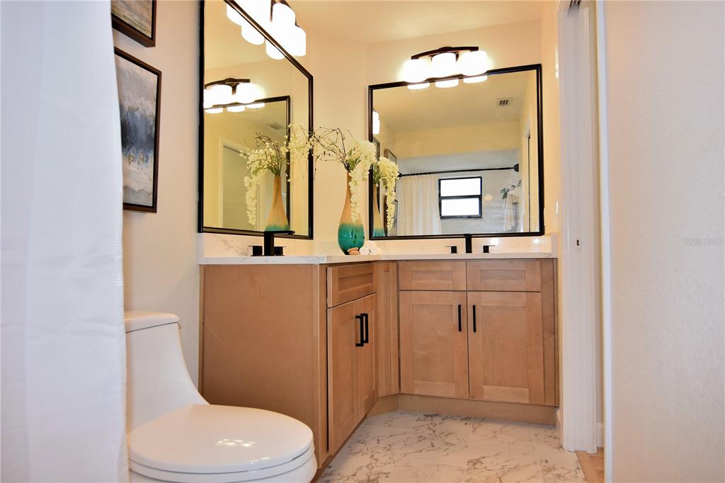 4014 Treetop Circle Spring Hill, FL 34606 - Photo 22 of 31 a bathroom with a toilet a sink a mirror and vanity