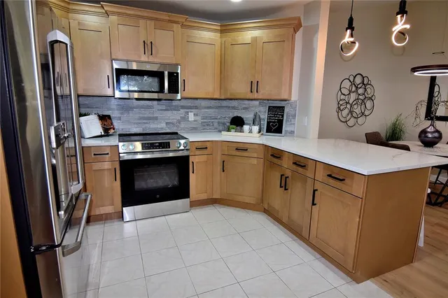 a kitchen with stainless steel appliances granite countertop a stove a sink and a refrigerator