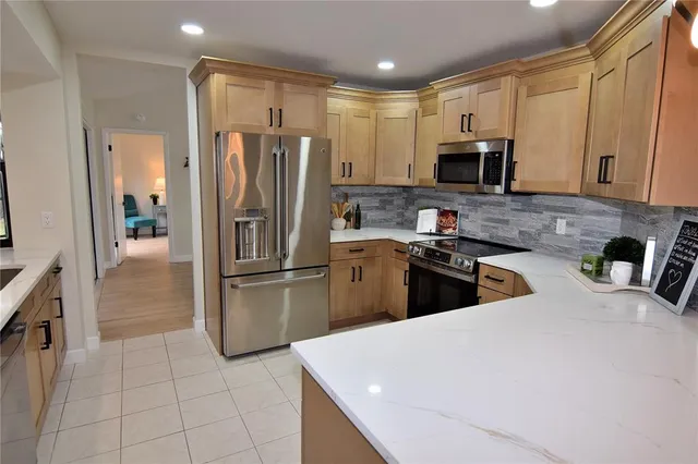 a kitchen with stainless steel appliances a refrigerator sink microwave and cabinets