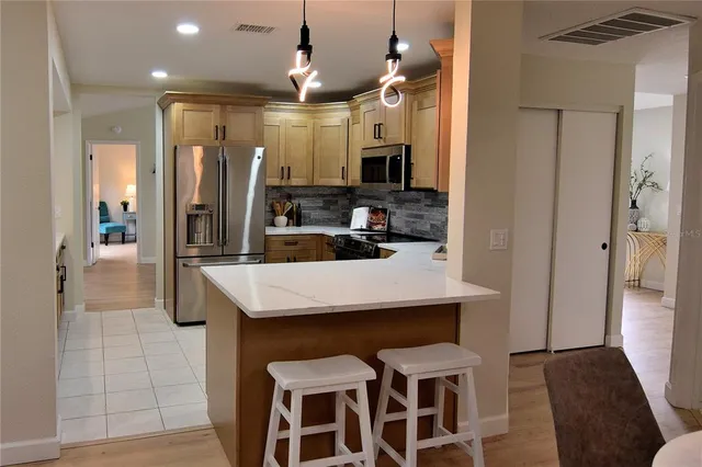 a kitchen with kitchen island a sink stove and refrigerator