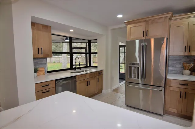 a kitchen with stainless steel appliances a refrigerator sink and cabinets