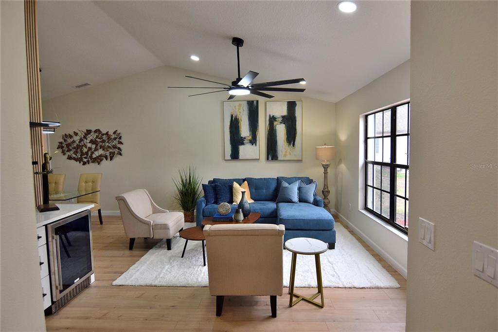 4014 Treetop Circle Spring Hill, FL 34606 - Photo 10 of 31 a living room with furniture a chandelier and a flat screen tv