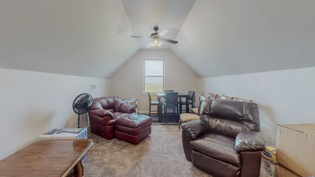 a living room with furniture and a ceiling fan