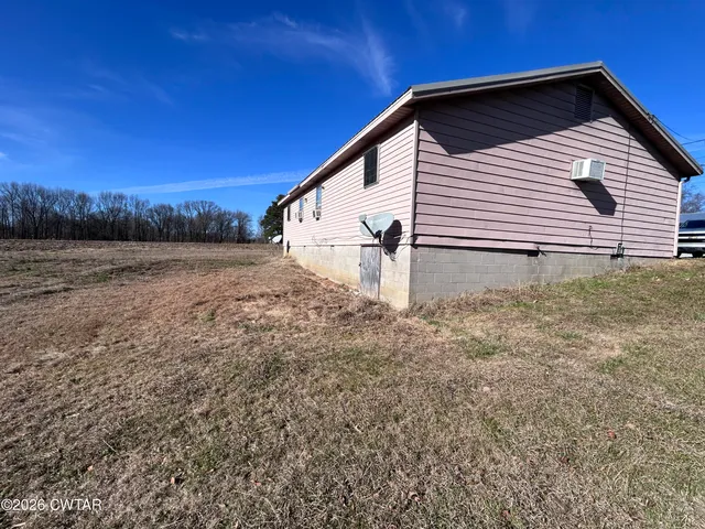 a view of a house with backyard and trees