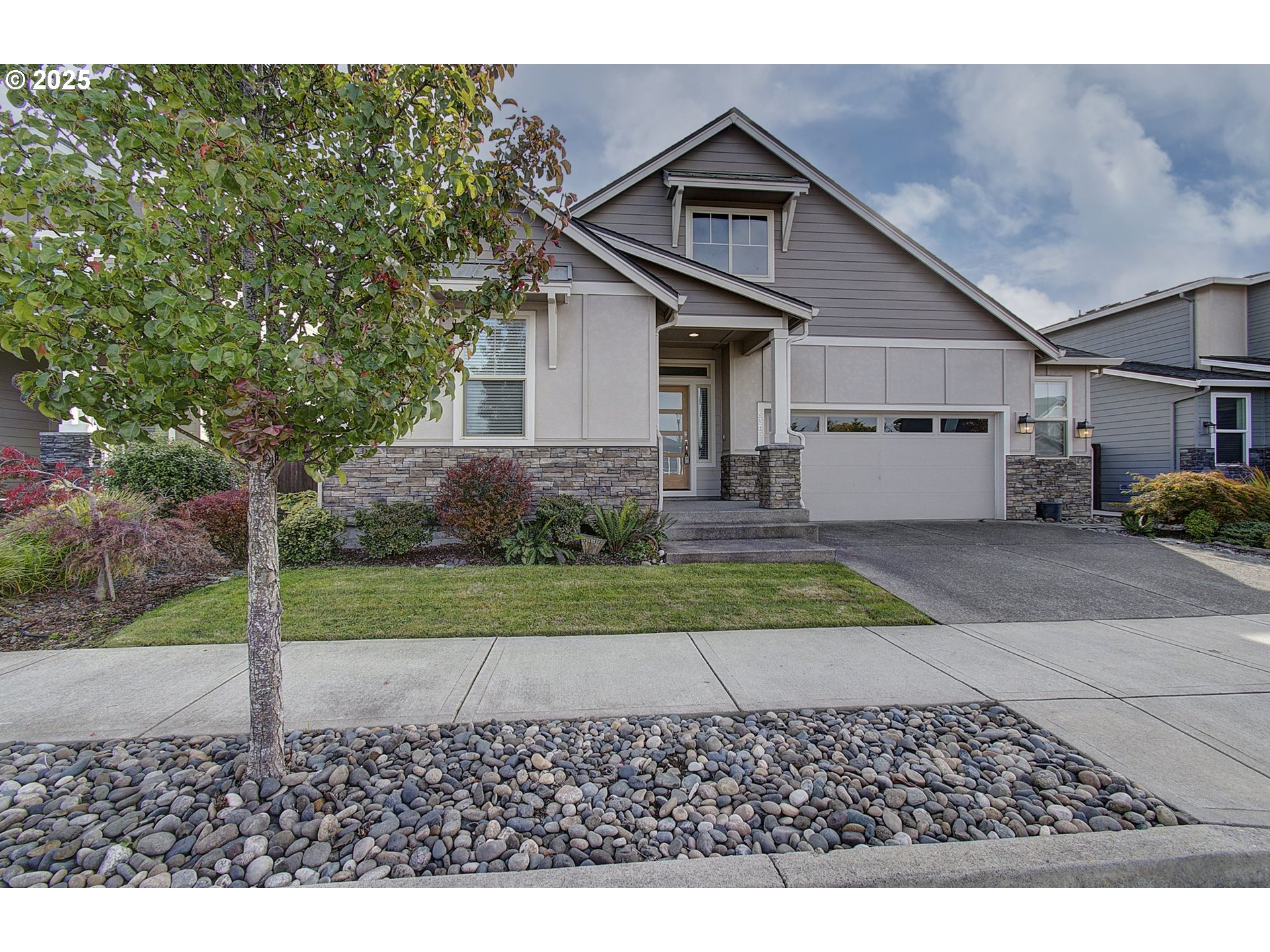 5305 Northeast 134th Street Vancouver, WA 98686 - Photo 2 of 36 a front view of a house with a yard and garage