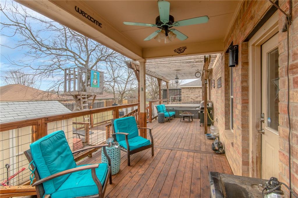 508 Emma Rose Trail Leander, TX 78641 - Photo 18 of 40 A spacious wooden deck provides ample outdoor living space, featuring a built-in pergola and a treehouse in the background.