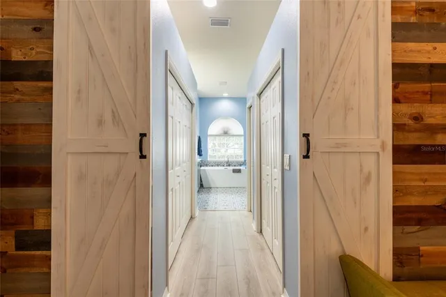 a view of a hallway with a livingroom and a bathroom with sink