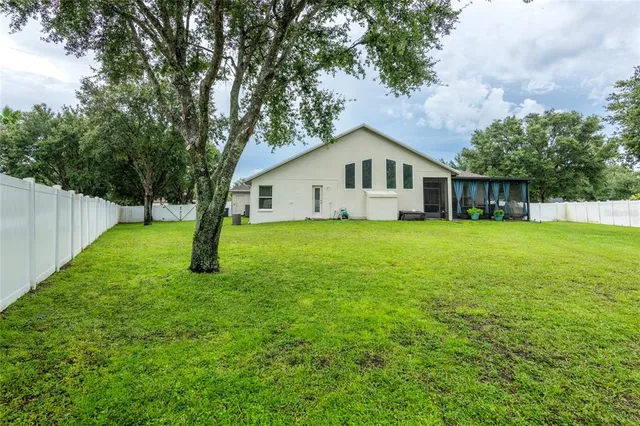 a house that is sitting in the grass with tress in the background