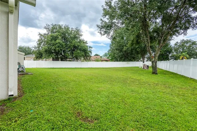 a aerial view of a house with a yard and large tree