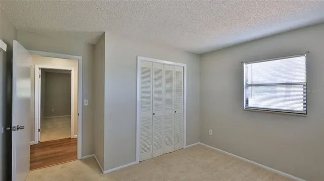 an empty room with windows and closet