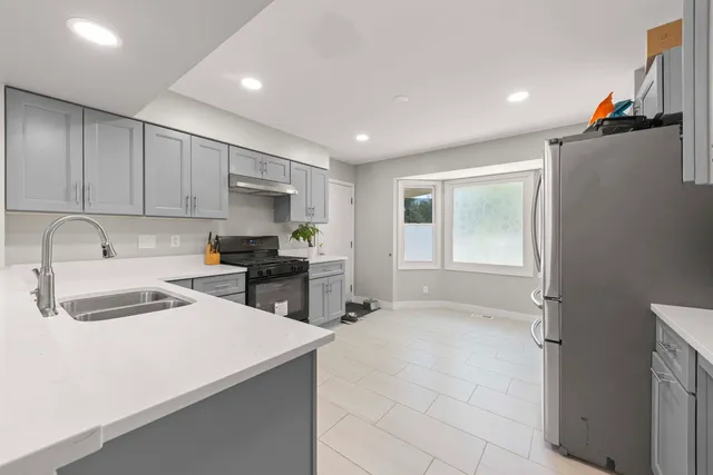 a kitchen with a refrigerator a sink and cabinets