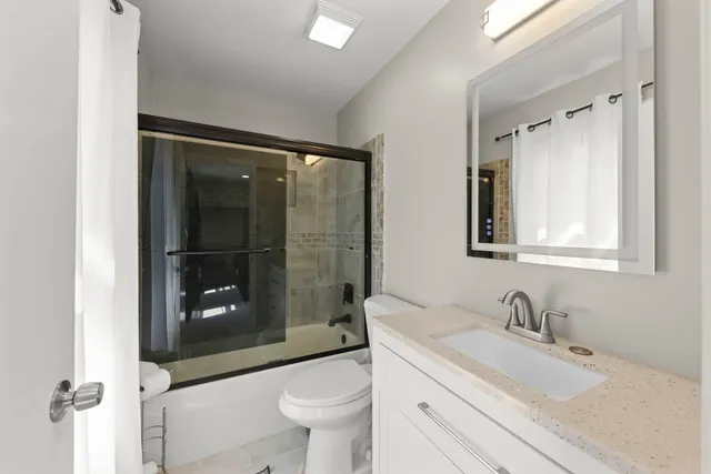 a bathroom with a sink toilet a mirror and shower