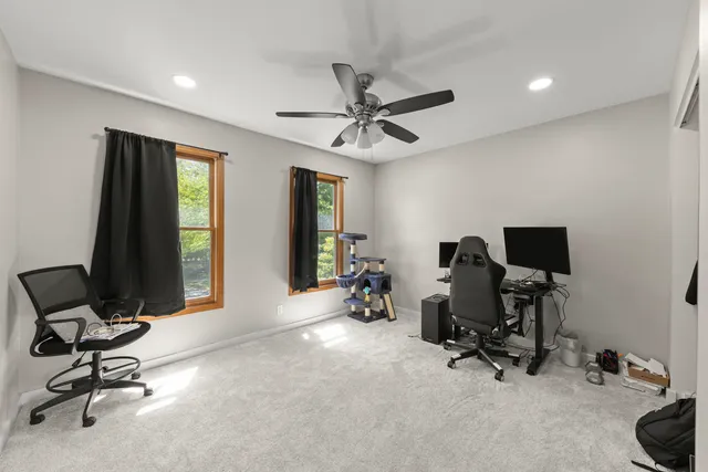 a view of a workspace with furniture and a window