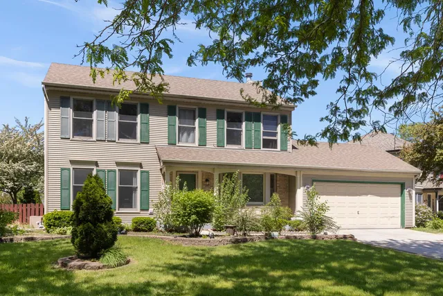 a front view of a house with a yard and a garden