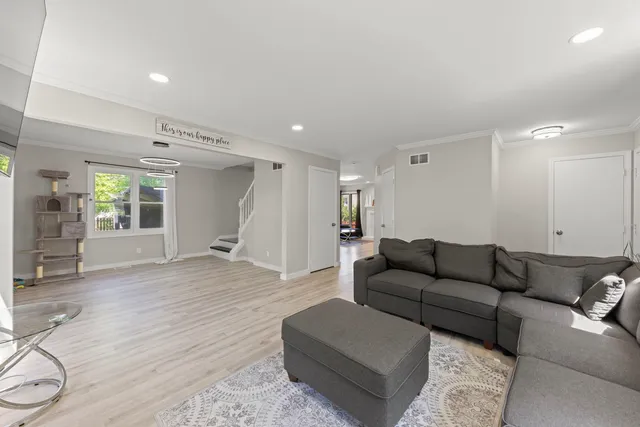 a living room with furniture and a wooden floor