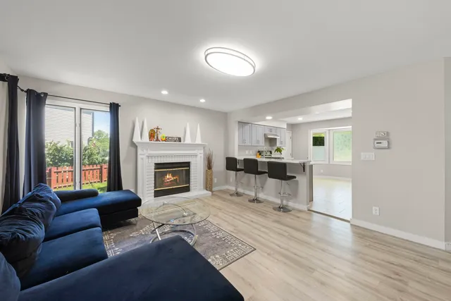 a living room with furniture a fireplace and a large window