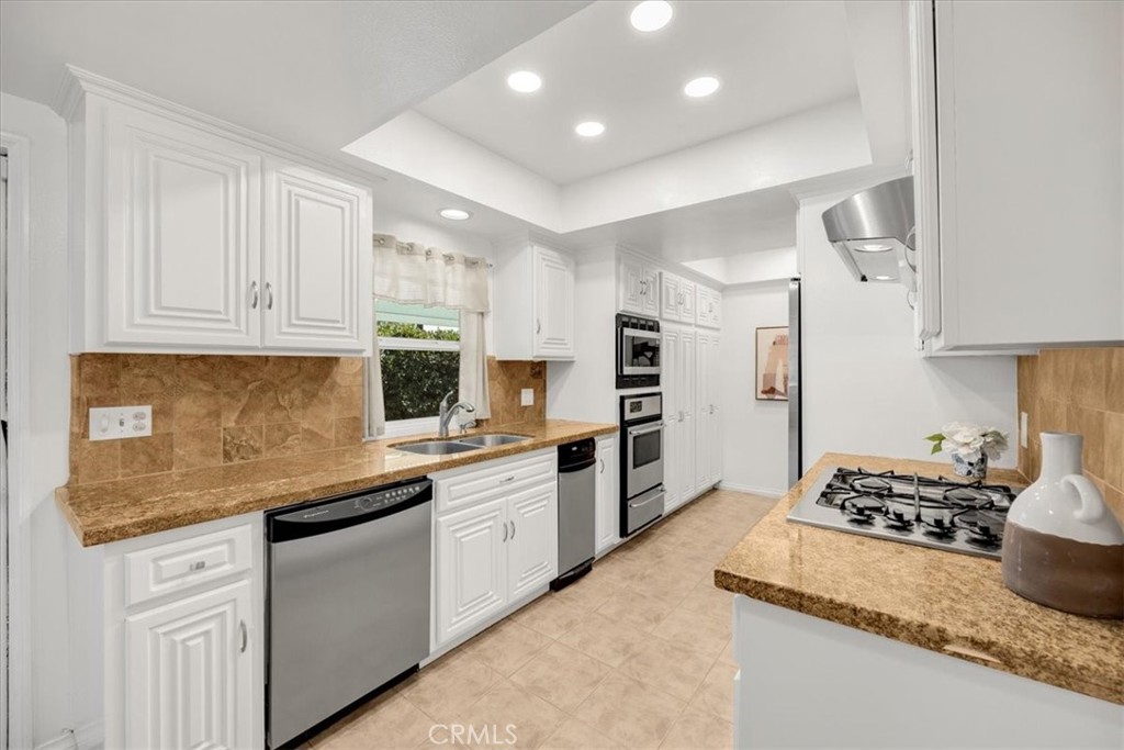 2956 Monogram Avenue Long Beach, CA 90815 - Photo 13 of 29 a kitchen with granite countertop kitchen island sink stove and white cabinets
