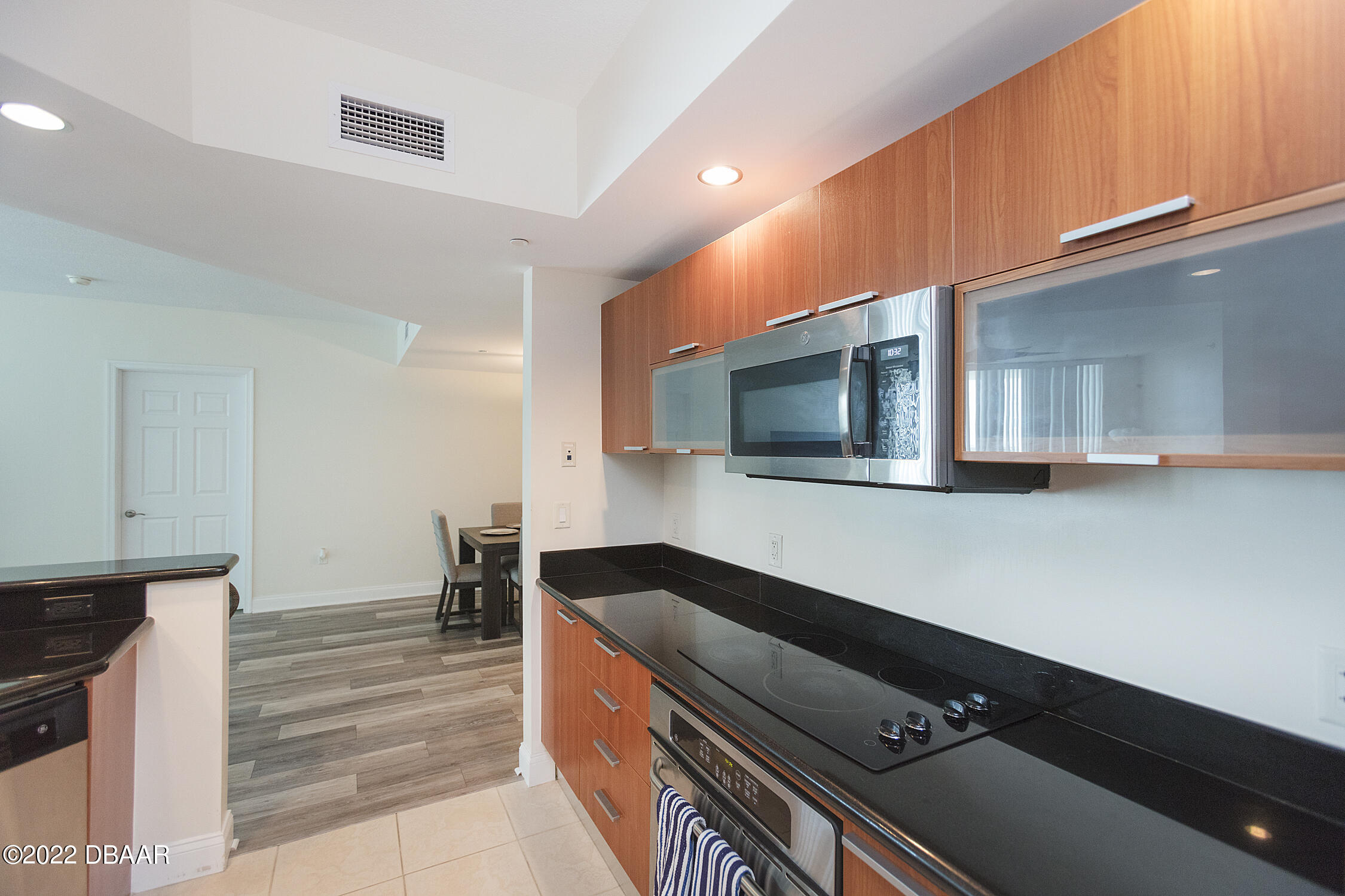 231 Riverside Drive, Unit 11061 Holly Hill, FL 32117 - Photo 19 of 64 a kitchen with stainless steel appliances kitchen island granite countertop a stove and a microwave