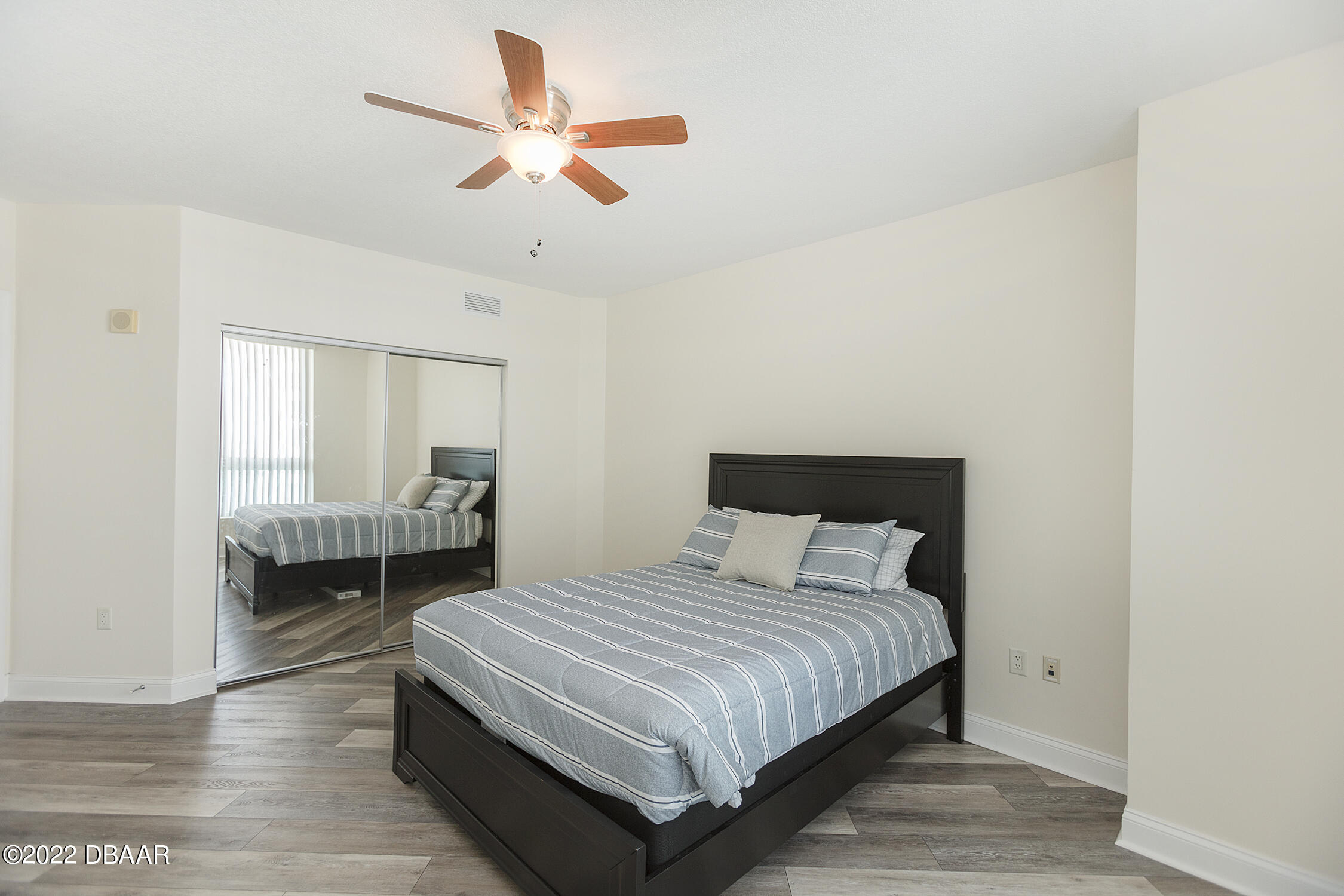 231 Riverside Drive, Unit 11061 Holly Hill, FL 32117 - Photo 36 of 64 a bedroom with a bed and a chandelier