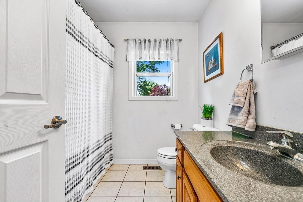 111 Wompatuck Road Hingham, MA 02043 - Photo 13 of 33 a bathroom with a granite countertop sink a toilet a mirror and shower
