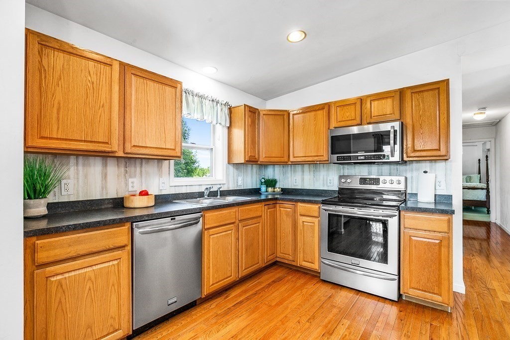 111 Wompatuck Road Hingham, MA 02043 - Photo 4 of 33 a kitchen with stainless steel appliances granite countertop wooden cabinets a sink and dishwasher a stove top oven with wooden floor