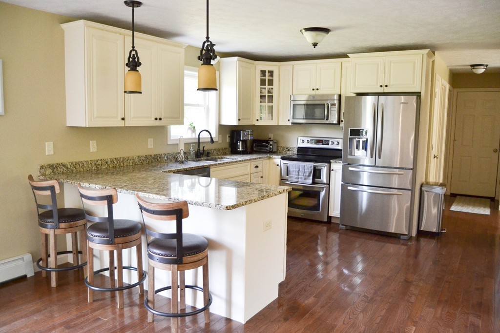 89 Davis Road Westminster, MA 01473 - Photo 6 of 25 a kitchen with stainless steel appliances granite countertop a refrigerator a stove top oven a sink dishwasher and white cabinets with wooden floor