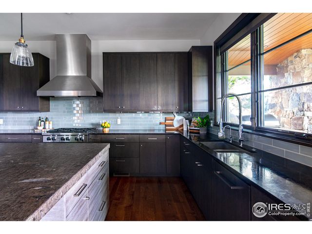 a kitchen with stainless steel appliances granite countertop a sink a stove and a wooden cabinets