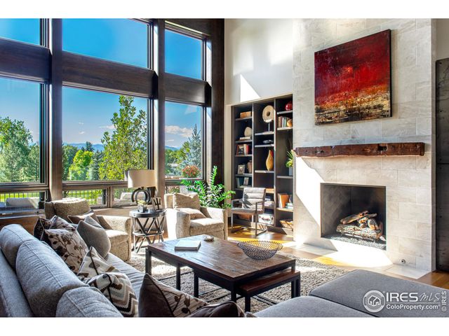 a living room with fireplace furniture and a large window