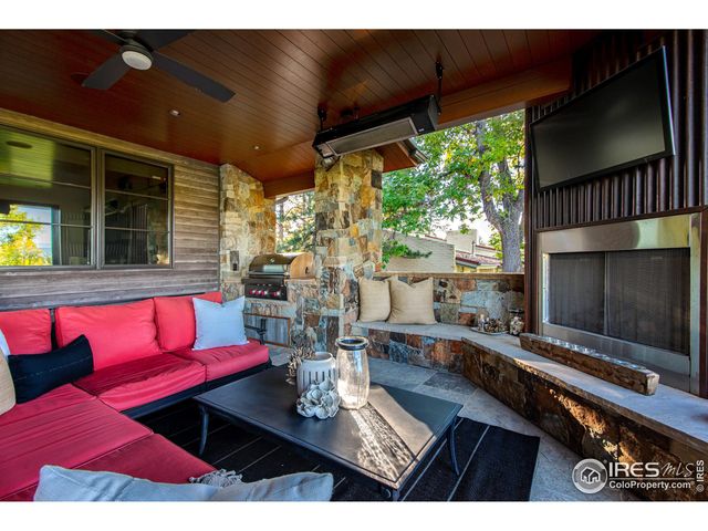 a living room with furniture a flat screen tv and a floor to ceiling window