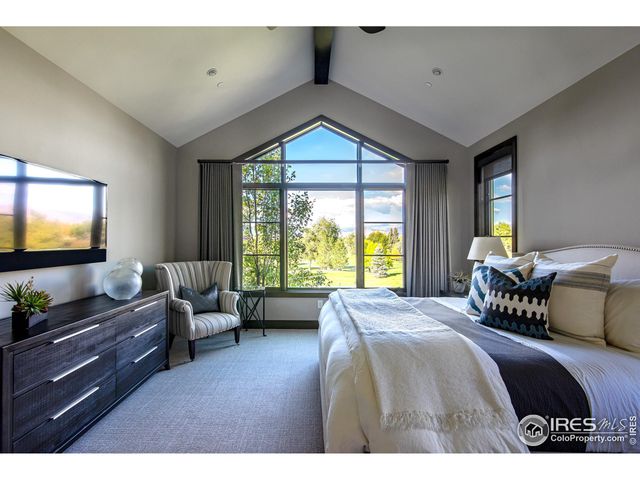 a bedroom with a bed and large windows