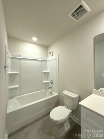 a white toilet sitting next to a bath tub